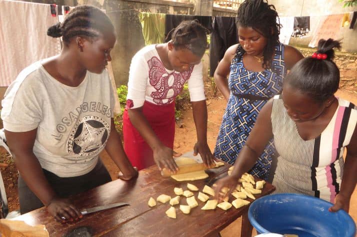 Mirembe (center) learning new skills through a catering classes.