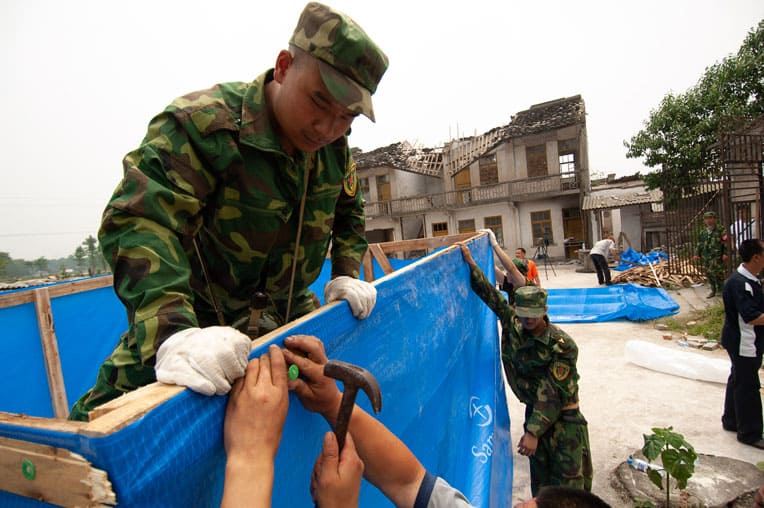 Local residents and Chinese military constructed emergency shelter with plastic sheeting provided by Samaritan's Purse.