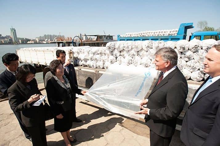 On behalf of Samaritan’s Purse, Franklin Graham delivers rolls of plastic sheeting to the city of Sinjiju, across the river from Dandong, China. The sheeting helped farmers protect seedlings from cold weather during early planting.