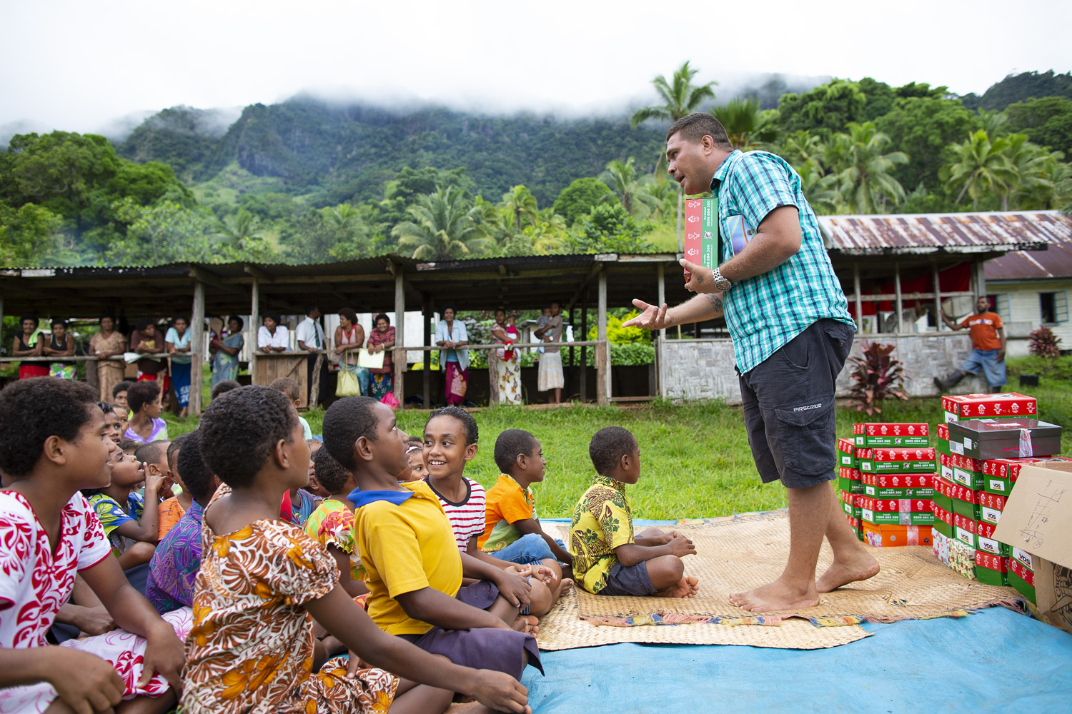 Volunteers sharing shoebox gifts in a field