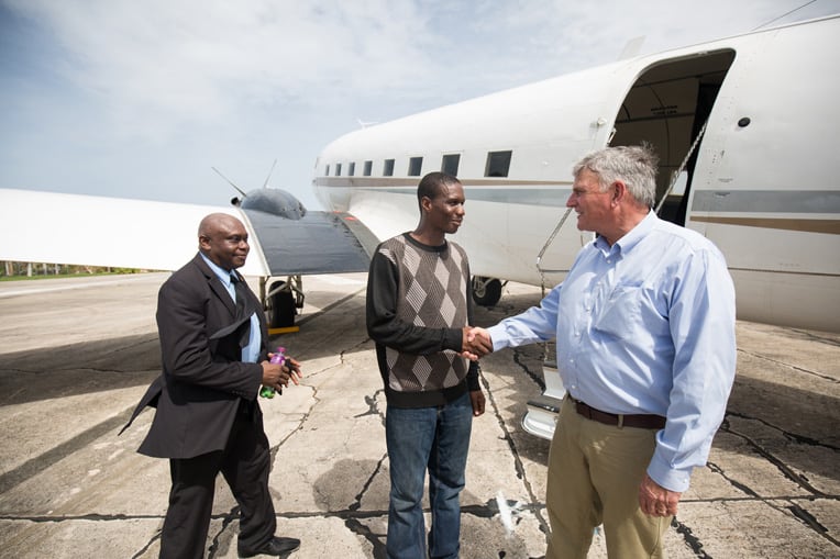 Francois Joseph and Pastor Nigel Henry (at left) greet Franklin Graham in Barbuda.