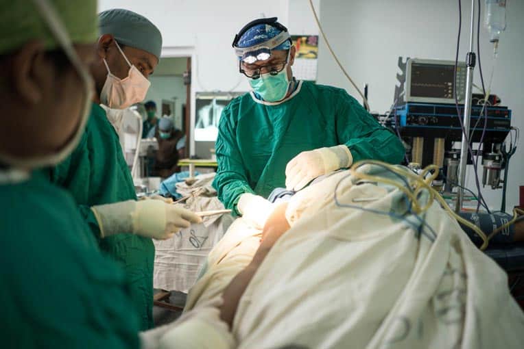 Surgeon Stephen Kelley performs an operation on a man's arm at Christian Memorial Hospital in Bangladesh.