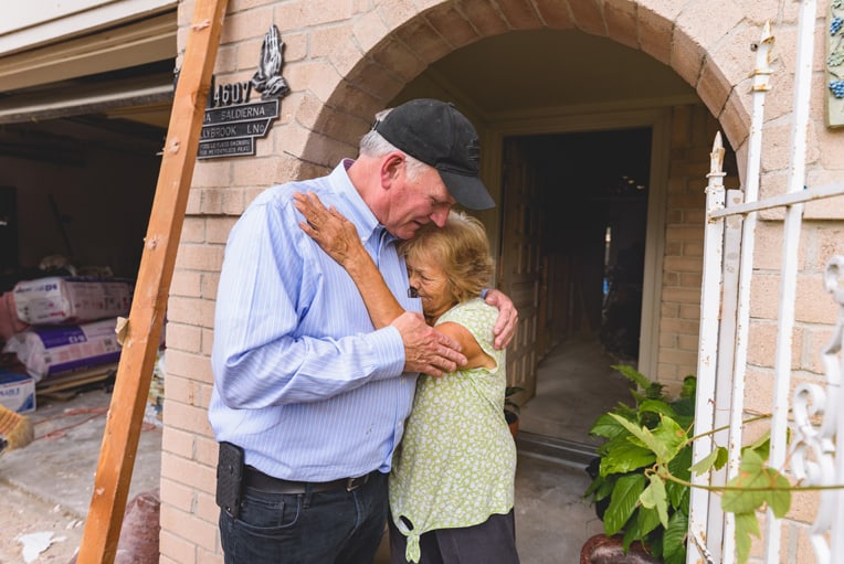 Franklin Graham helps console Margarita Cruz Saldierna, who was tearful as she talked about the storm's damage to her home.
