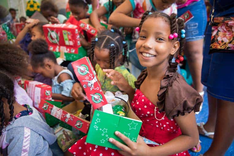 A beautiful smile brightens the face of a young girl in the Dominican Republic as she receives an Operation Christmas Child shoebox gift.