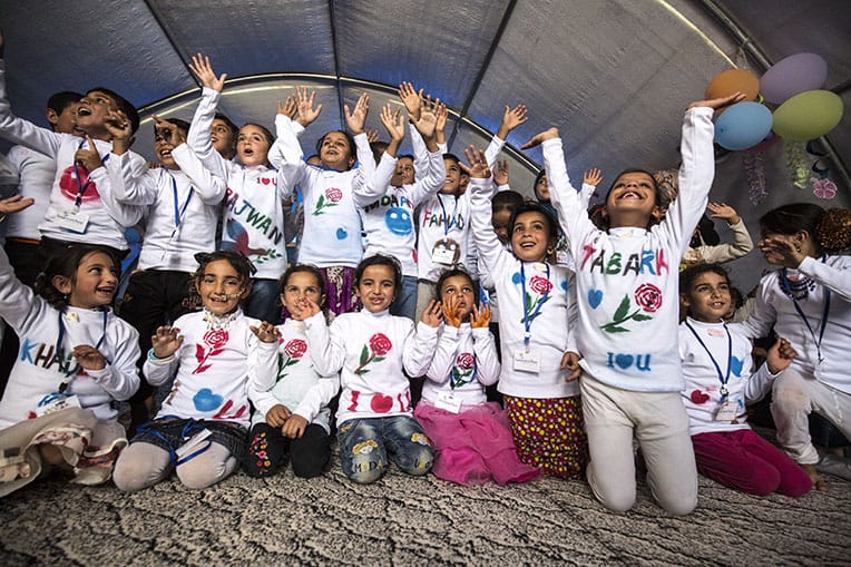 After their graduation, child-friendly space graduates celebrate in the shirts they made in class.