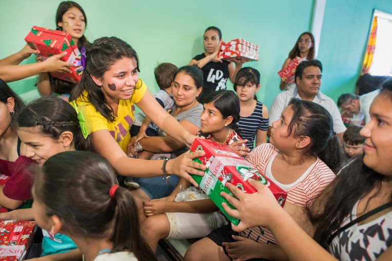 Jazmin helps distribute Operation Christmas Child shoebox gifts to girls in the 10 to 14-year-old age group.