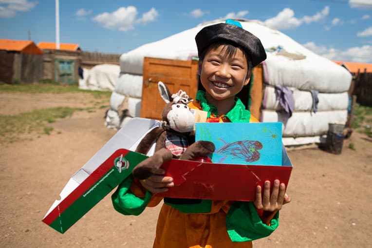 A boy in Mongolia smiles after receiving his “wow” toy and a personal note in the shoebox gift lovingly packed just for him.