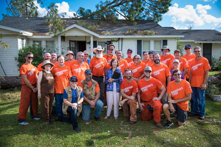 Vera Rozier gathers with the Samaritan's Purse volunteers who helped clean up her yard and house.