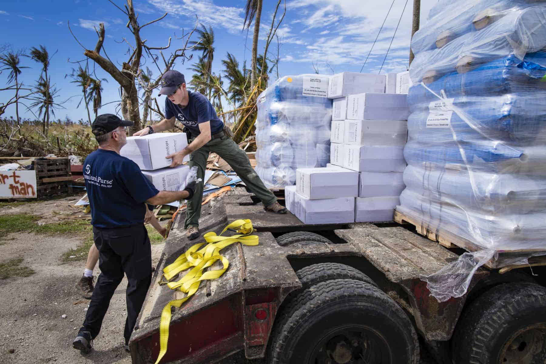 Disaster response specialists unload water filtration units, solar lights, and emergency shelter materials to be distributed to families devastated by Typhoon Yutu.