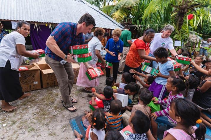 Edward Graham helps distribute shoebox gifts during an outreach event to local villages.