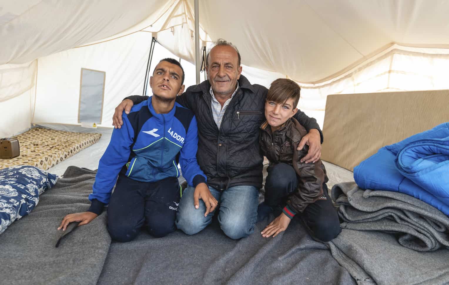 Diyar (center) and his two sons find refuge in their tent.
