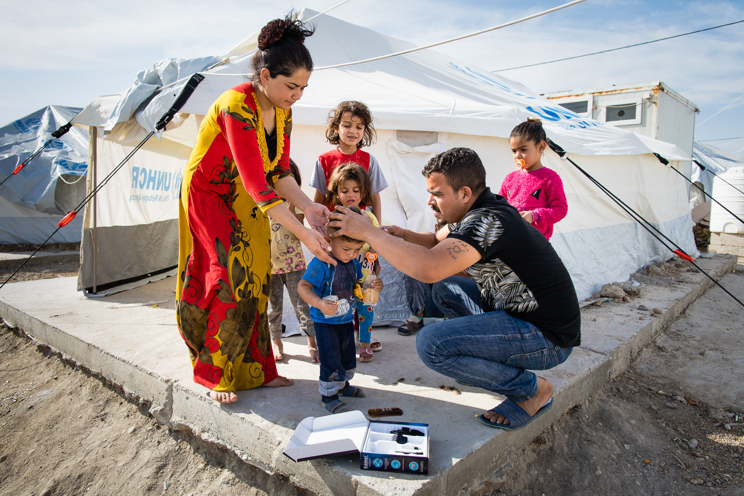 A young refugee receives a haircut in Bardarash camp.
