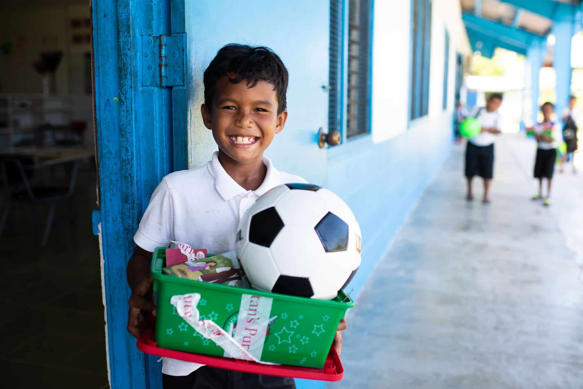 A boy from Peleliu island celebrates the “wow” toy in his gift-filled shoebox.