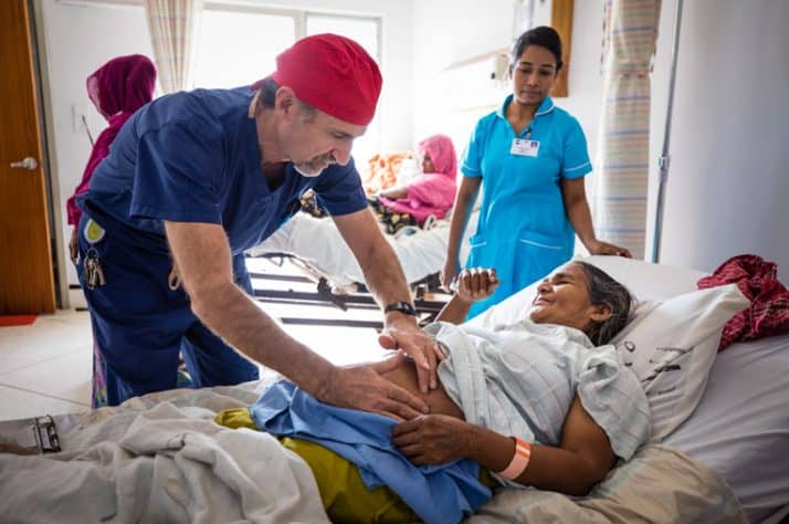 Dr. Stephen Kelley, chairman of the hospital's surgical department, checks on a patient during medical rounds.