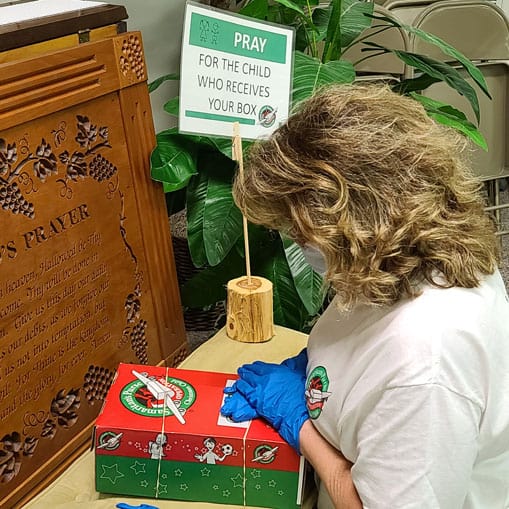 Even while taking sanitary measures, members of Milan Baptist in Maynardville, Tennessee, remember to pray over each shoebox gift they pack.