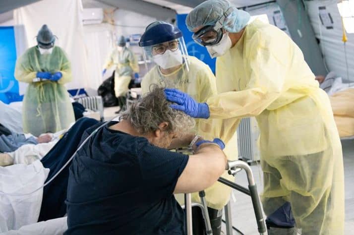Dr. Julie McKay prays for Umberto after his transfer from the ICU, where he was on a ventilator for more than two weeks.