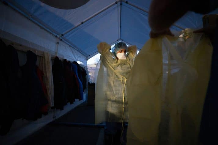 A night shift nurse dons her personal protective equipment.