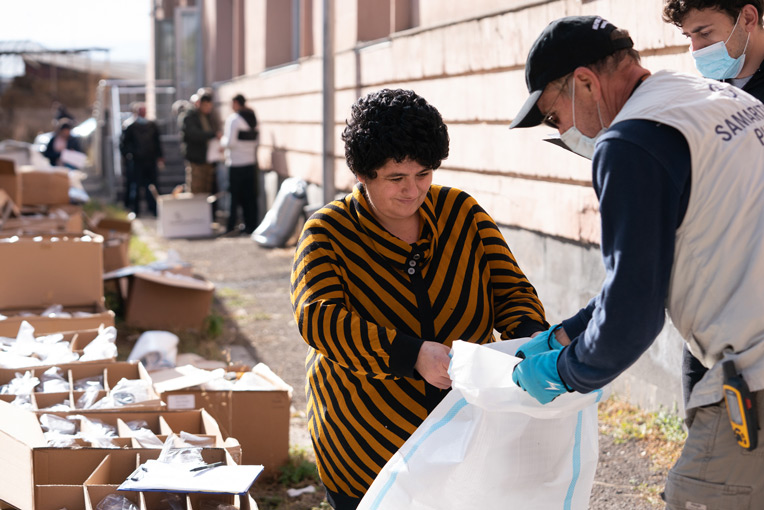 Nazely collects winter clothing items for her family at the Samaritan's Purse distribution in Vardenis, Armenia.