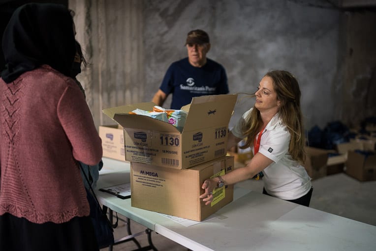 Canadian DART member Michelle Mcilveen helps distribute relief items to a mother in need.