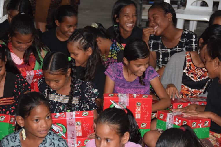 Girls from the Kwajalein Atoll delight in exploring the gifts inside their shoeboxes.