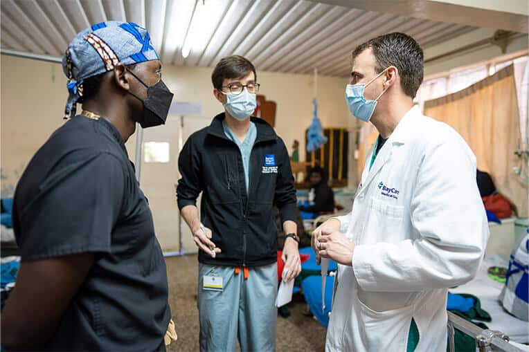 Dr. Fitzwater (right) confers  Dr. David Holmes (center), another World Medical Mission short-term volunteer, and a Kenyan resident.