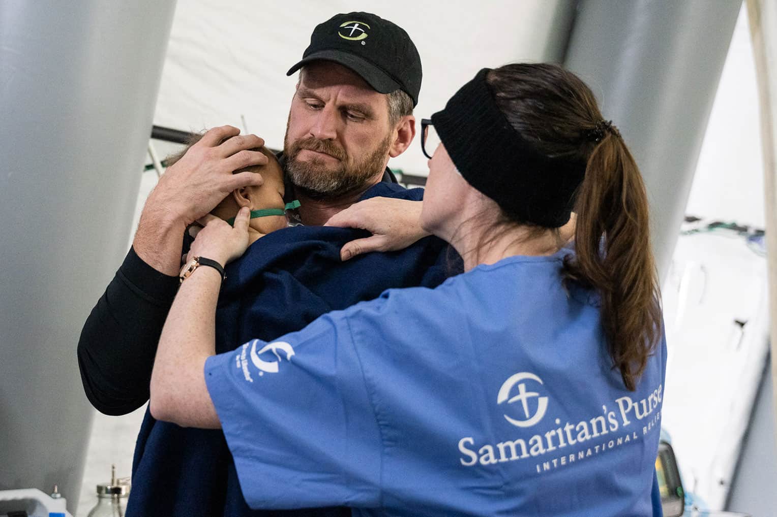 Edward holds 1-year-old Selim whose life was saved through interventions by our doctors and nurses.