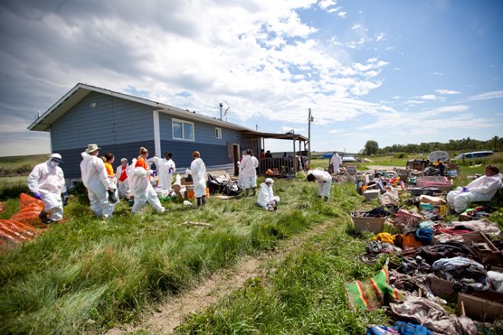 Debris and volunteers outside a home