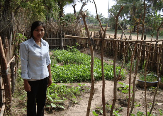 Woman stands next to garden