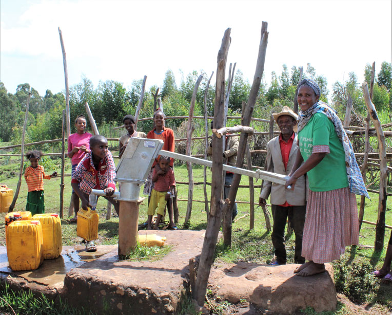 Residents in Korido test out the repaired water pump that's recently made water available to them again.