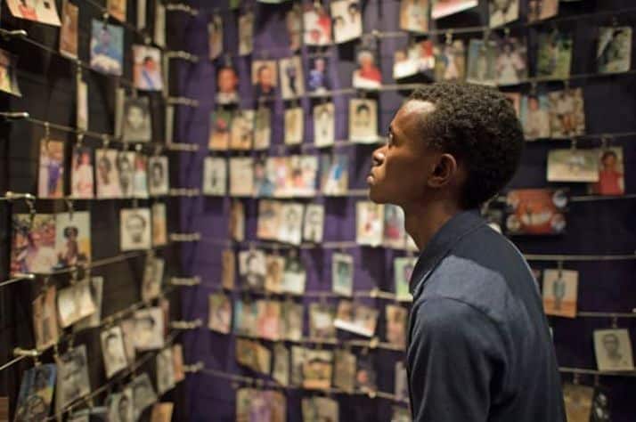 Alex looks at photos of genocide victims on display at Kigali Genocide Memorial Center.