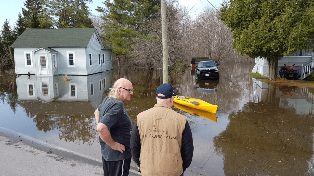 Andy Northup, a site leadership team member, speaks with a local homeowner as our team assesses the flood damage.