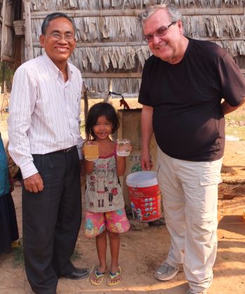 Mr. Viriya and Dr. Manz stand with the six-year-old daughter of Mrs. Teum Ros.  Mrs. Ros is a widow, has three girls under the age of nine, and spends all day collecting cow manure to sell. If she works hard, she can maybe make $3 a day—real poverty. At least her family has a choice about the water they drink.