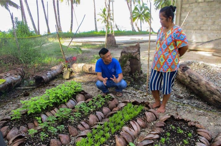 FAITH GARDENS: One of our partners helps a woman grow a FAITH (Food Always In The Home) garden near her home in Indonesia.
