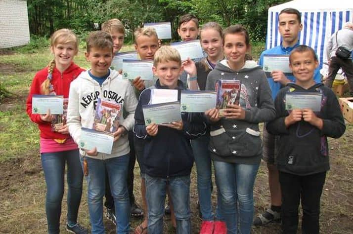 Ukraine children proudly show the graduation certificates they received after completing The Greatest Journey evangelism and discipleship program.
