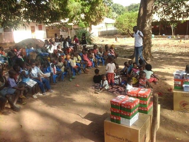 Children in Guinea Bissau hear the Good News of Jesus Christ before receiving gift-filled shoeboxes at an Operation Christmas Child distribution event.