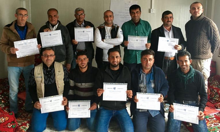 Fathers in Salim’s parenting class pause to commemorate the end of their six-day course.