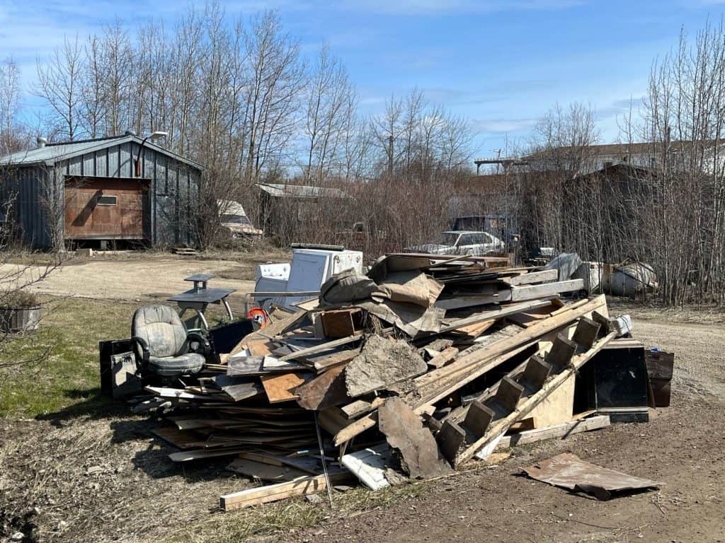 Water-damaged debris sits piled in front of a property in Hay River, NWT.