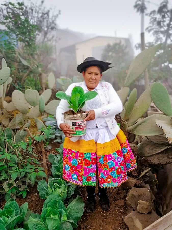 A woman holding cucumbers from her garden