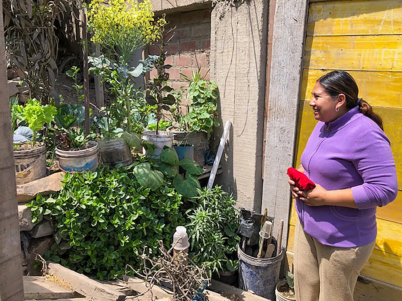 Josselyn celebrates her growing garden. The mother of two holds
a recycled container, now turned into a planter, that will sprout
with nutritious vegetables to feed her children.
