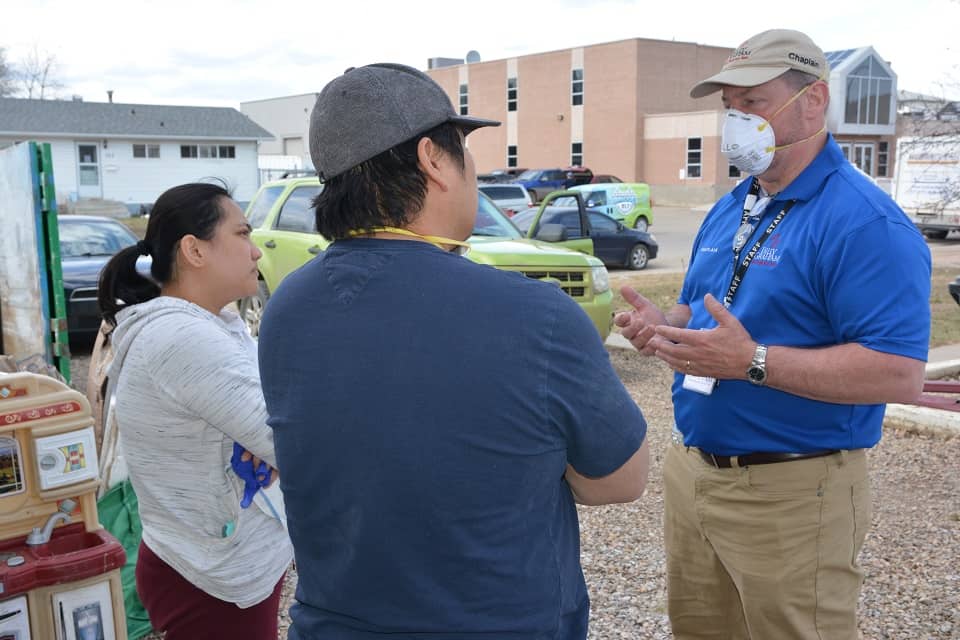 Billy Graham Rapid Response Team chaplain Merle Doherty (right) provides spiritual and emotional care to Fort McMurray AB flood victims Charity and Garry Jimenez. “We really needed spiritual healing,” Charity said.