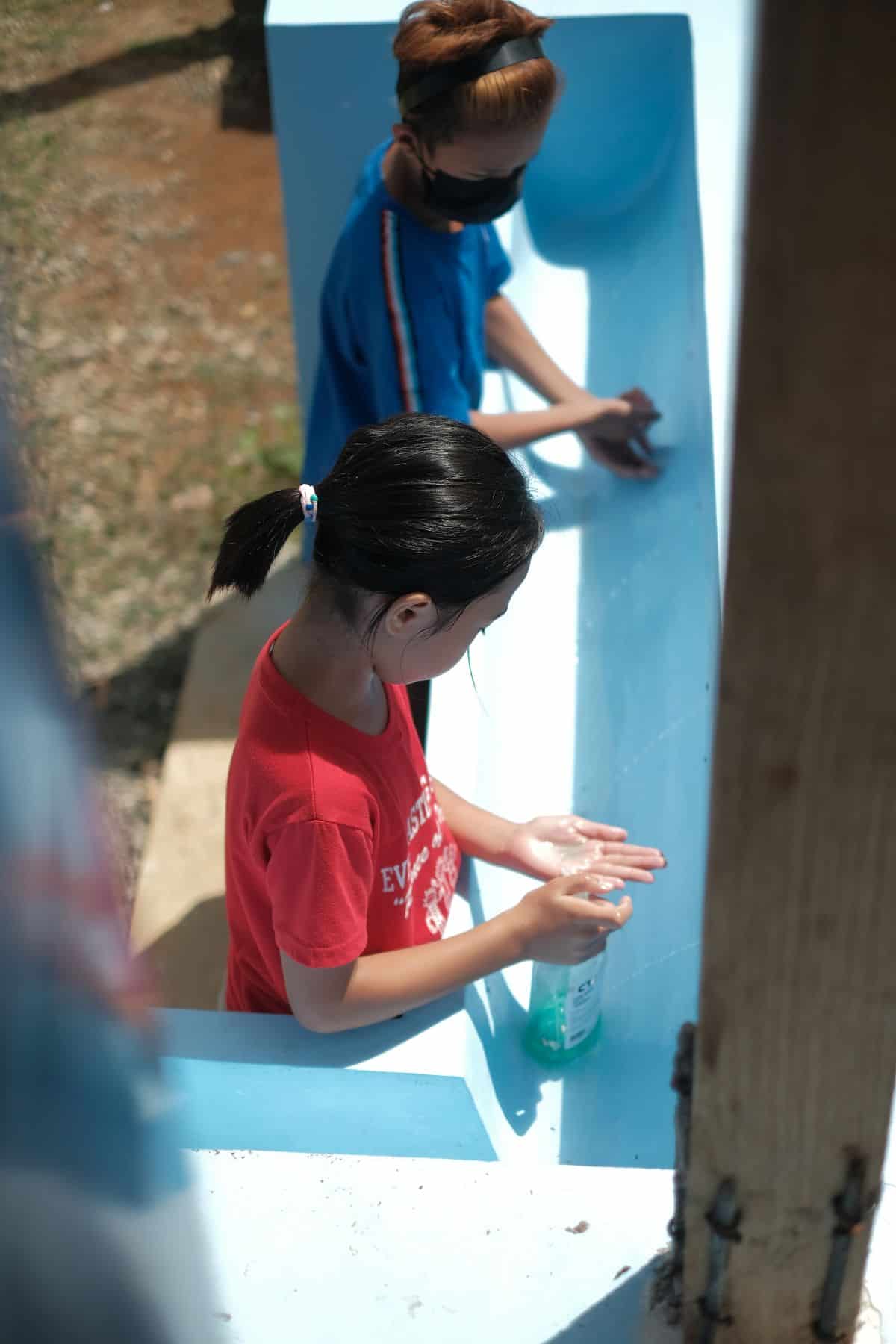 Handwashing is a crucial part of protecting the health of students like Abby. Here, she uses the handwashing stations that come with the BioSand Water filter at her school.