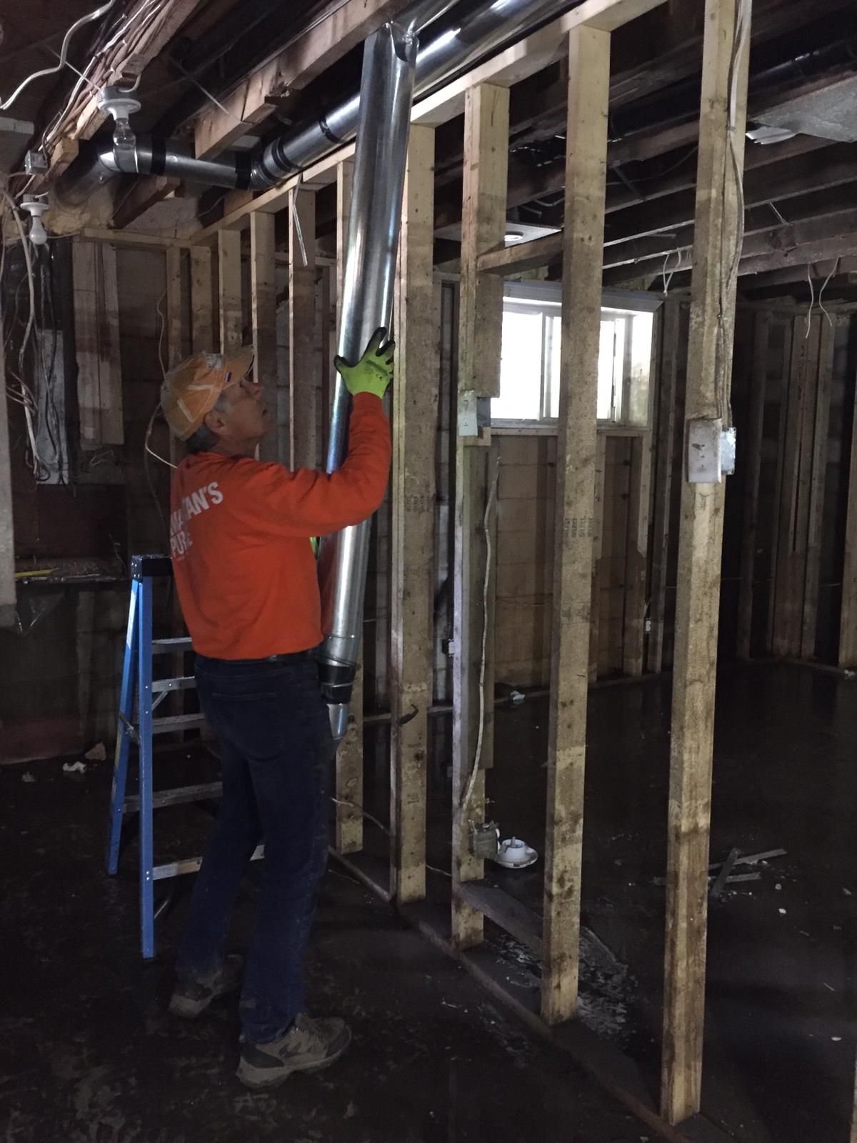 A Samaritan's Purse volunteer removes damaged duct work from a home in Renfrew County, ON.