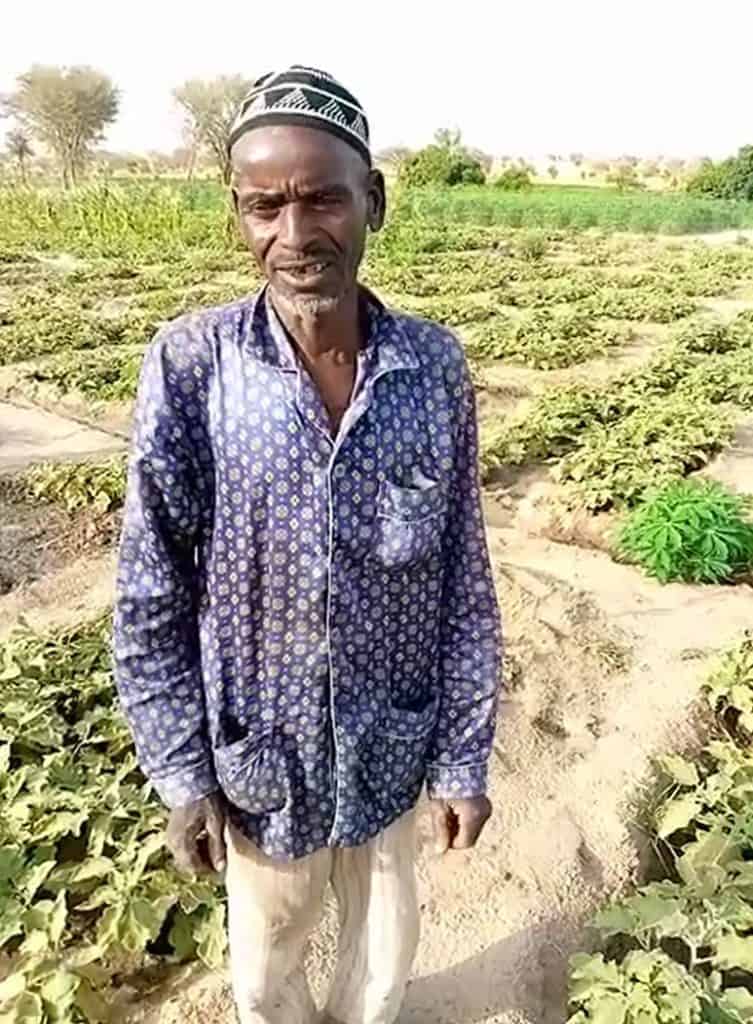 Ibrahim proudly stands before his family's flourishing garden In Niger.