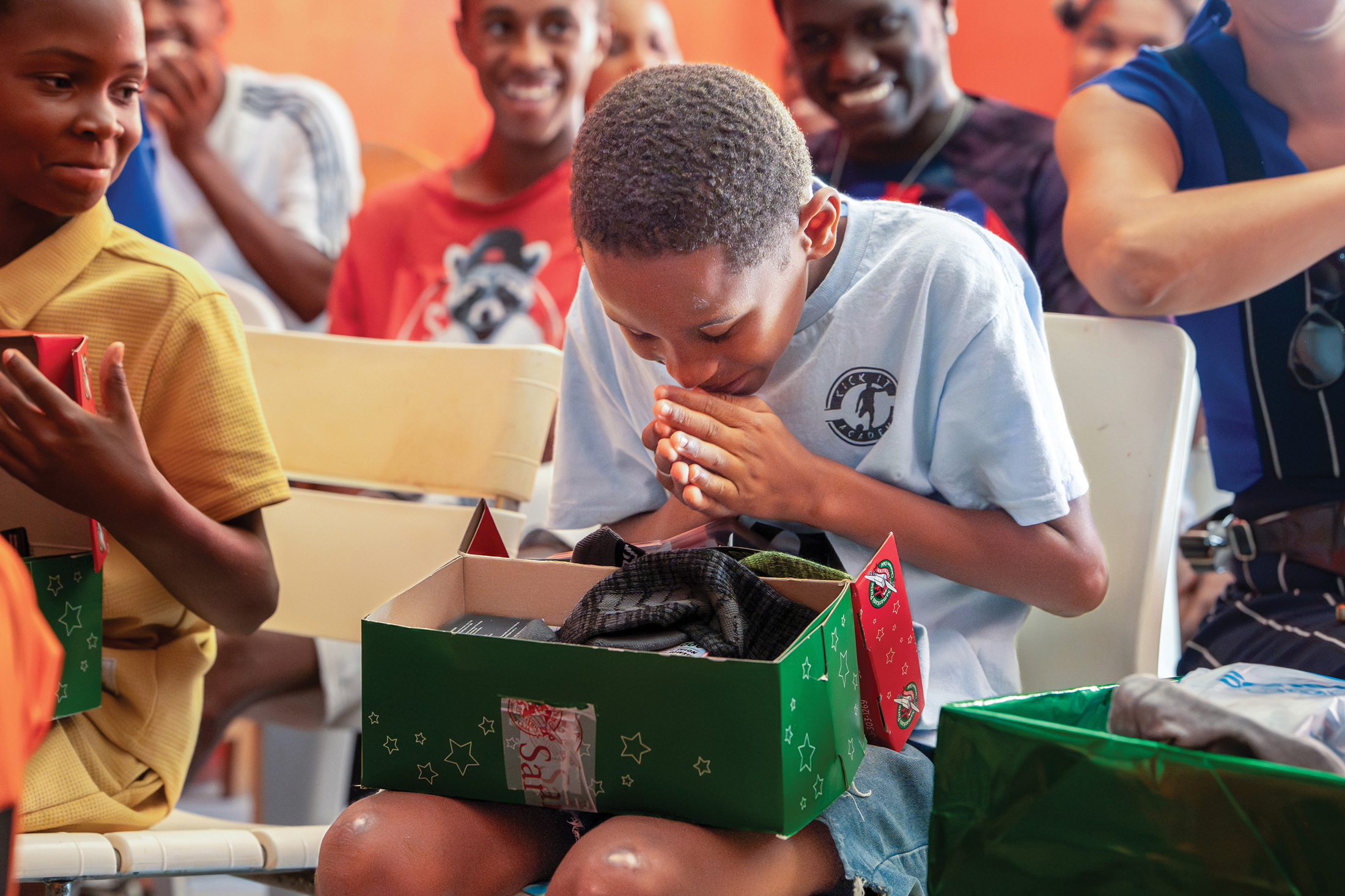 Diego smiles as he holds items from his Operation Christmas Child shoebox, including the bright green athletic socks he longed for.