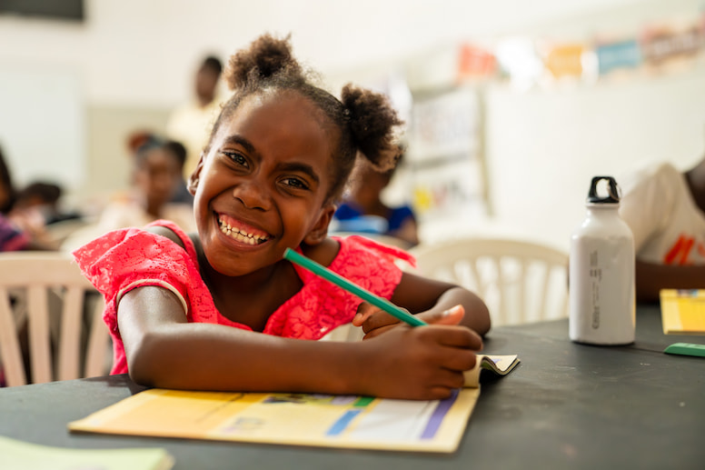 Child writing in a workbook.