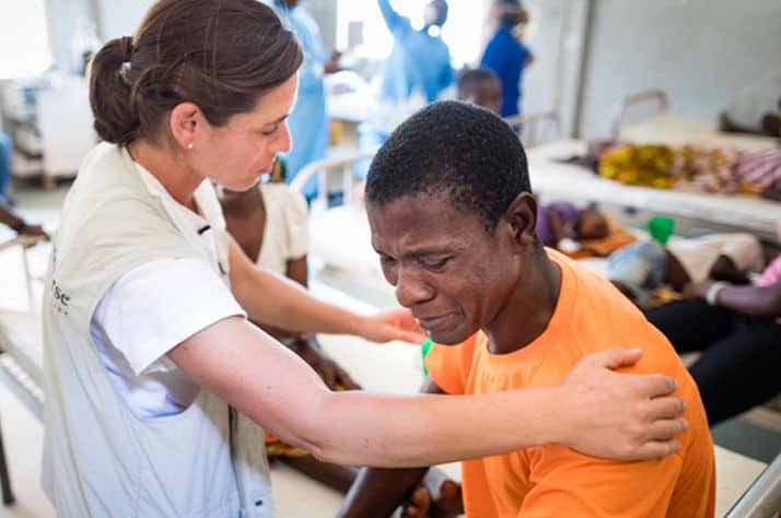Nurse Kelly Sutor prays with patient Agusto Americo who was injured after Cyclone Idai ripped through Mozambique. Samaritan's Purse is providing medical care where injury and infection are threatening isolated communities.