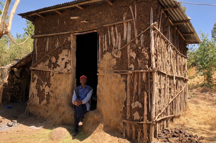 Seifu Sileshi sits in the doorway of him home.
