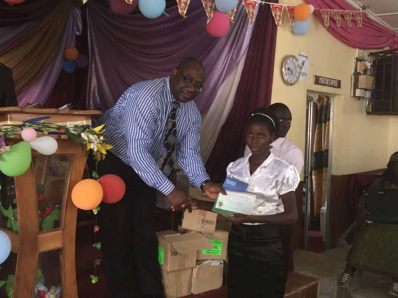 A Sierra Leone pastor gives a certificate to a graduate of The Greatest Journey, Samaritan’s Purse’s 12-lesson evangelism and discipleship program.