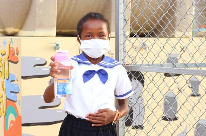 Chivy stands in front of the new community BioSand Water Filter at her school in Cambodia.