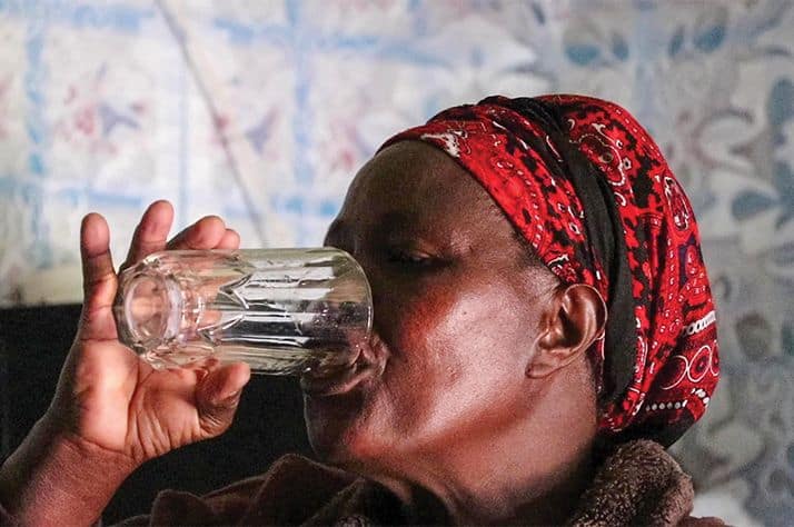 Alice drinks water from her BioSand Filter, free of the fear that she'll get sick.